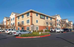 a large building with cars parked in a parking lot at Extended Stay America Suites - Sacramento - Roseville in Roseville