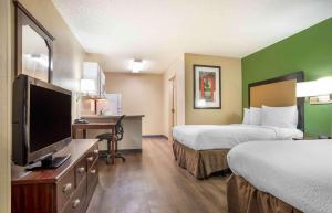 a hotel room with two beds and a flat screen tv at Extended Stay America Select Suites - Jackson - North in Jackson