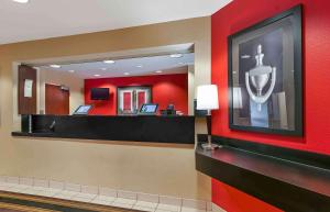 a hotel lobby with a mirror and red walls at Sonesta Simply Suites Lansing in Lansing