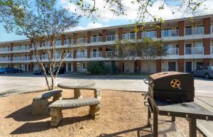 a picnic table and a grill in front of a building at Extended Stay America Suites - Houston - The Woodlands in The Woodlands