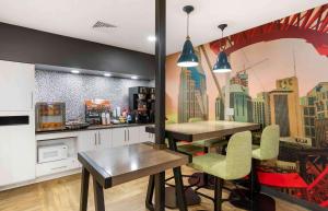 a kitchen with two tables and a mural of a city at Extended Stay America Premier Suites - Nashville - Vanderbilt in Nashville