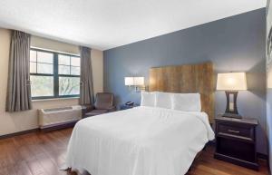 ein Hotelzimmer mit einem großen Bett und einem Stuhl in der Unterkunft Extended Stay America Premier Suites - Nashville - Vanderbilt in Nashville