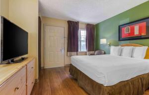 ein Hotelzimmer mit einem Bett und einem Flachbild-TV in der Unterkunft Extended Stay America Suites - Phoenix - Scottsdale - Old Town in Scottsdale