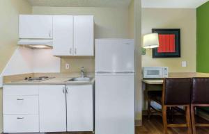 uma cozinha com armários brancos e um frigorífico branco em Extended Stay America Suites - Phoenix - Scottsdale - Old Town em Scottsdale