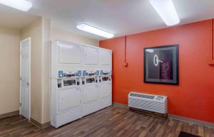 una lavandería con electrodomésticos blancos y una pared de color naranja en Extended Stay America Suites - Houston - Galleria - Westheimer en Houston