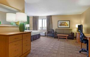 a hotel room with a bedroom with a bed and a couch at Extended Stay America Select Suites - Madison - Old Sauk Rd in Madison