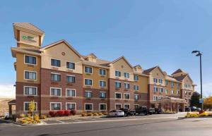 Un gran edificio con coches aparcados en un estacionamiento. en Extended Stay America Suites - Denver - Park Meadows, en Lone Tree