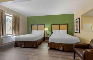 two beds in a room with green walls at Extended Stay America Select Suites - Dallas - Las Colinas - Meadow Creek Dr in Irving