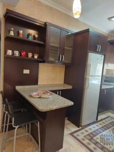 a kitchen with a counter and a refrigerator at Elegant Home in Amman