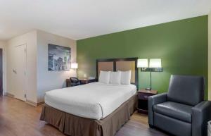 Extended Stay America Suites - Fremont - Warm Springs في Warm Springs District: غرفه فندقيه بسرير وكرسي
