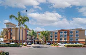 een hotel met auto's geparkeerd op een parkeerplaats bij Extended Stay America Suites - Orange County - Katella Ave in Orange