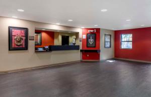 an empty lobby with red walls and a waiting room at Extended Stay America Suites - Orange County - Katella Ave in Orange