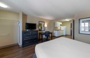 een slaapkamer met een bed, een televisie en een bureau bij Extended Stay America Suites - Orange County - Katella Ave in Orange