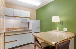 a kitchen with green walls and a white refrigerator at Extended Stay America Suites - Orange County - Irvine Spectrum in Irvine