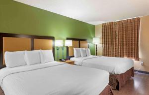 a hotel room with two beds and a green wall at Extended Stay America Suites - Orange County - Irvine Spectrum in Irvine