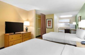 a hotel room with two beds and a flat screen tv at Extended Stay America Suites - Orange County - Irvine Spectrum in Irvine