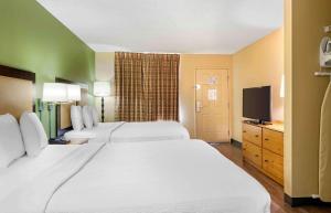 a hotel room with two beds and a flat screen tv at Extended Stay America Suites - Orange County - Irvine Spectrum in Irvine