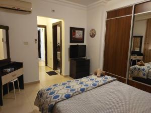 Elegant Home في عمّان: غرفة نوم فيها سرير وتلفزيون