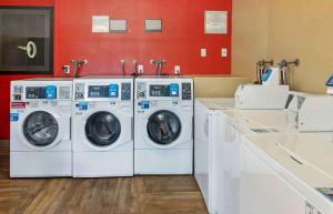 two washing machines in a laundry room with red walls at Extended Stay America Suites - Orange County - Irvine Spectrum in Irvine