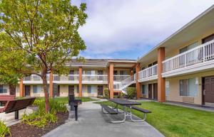 a courtyard with a picnic table and benches in front of a building at Extended Stay America Suites - San Francisco - San Mateo - SFO in San Mateo