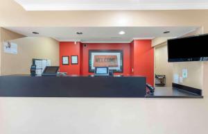 una sala de espera con paredes rojas y un mostrador en Extended Stay America Suites - Richmond - West End - I-64 en Short Pump