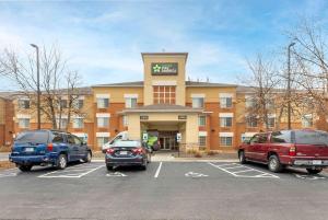 Un edificio con coches aparcados en un estacionamiento. en Extended Stay America Select Suites - St Louis - Airport - Central, en Bridgeton