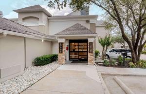 a house with a driveway leading to the front door at Extended Stay America Suites - Dallas - Coit Road in Dallas
