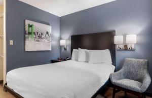 a bedroom with a large bed and a chair at Extended Stay America Suites - Dallas - Coit Road in Dallas