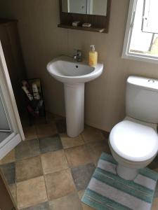 a bathroom with a white toilet and a sink at Devon Cliffs Exmouth Sandy Bay 3 bedrooms in Exmouth