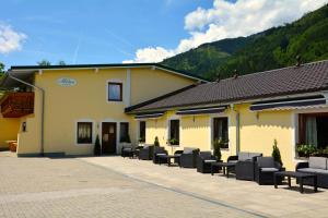 a group of chairs sitting outside of a building at Pension Milan in Zell am See