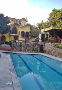uma grande piscina azul em frente a uma casa em Finca de Recreo en Guaduas em Guaduas