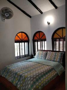 um quarto com uma cama e 3 janelas em Finca de Recreo en Guaduas em Guaduas