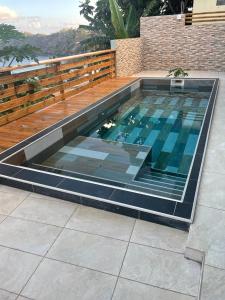 una gran piscina con terraza de madera en Le Lointain, en Mtsamboro