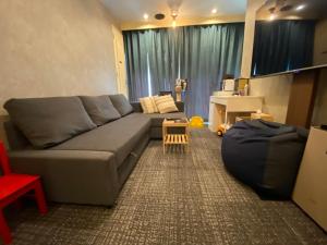 uma sala de estar com um sofá cinzento e uma mesa em 54Journey Roppongi em Tóquio