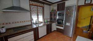 eine Küche mit einem Kühlschrank und Schränken aus Edelstahl in der Unterkunft Villa Mercedes in Luarca