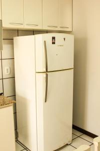 a white refrigerator in a kitchen with white cabinets at Apartamento amplo e completo no centro Balneário Camboriú in Balneário Camboriú