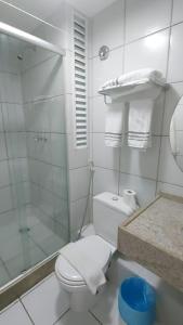 a bathroom with a toilet and a glass shower at Gran Lençóis Flat Barreirinhas in Barreirinhas