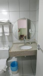 a bathroom with a sink and a mirror and a toilet at Gran Lençóis Flat Barreirinhas in Barreirinhas