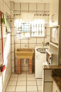 a small kitchen with a sink and a window at Apartamento amplo e completo no centro Balneário Camboriú in Balneário Camboriú