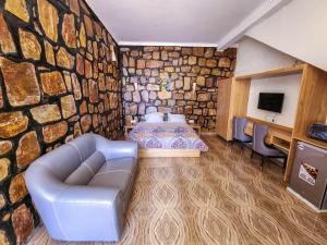 a room with a stone wall with a couch and a table at Kigali Eye Studio Apartments in Kigali