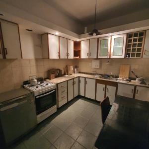 a kitchen with white cabinets and a stove top oven at Güemes Hostel Cordoba in Cordoba