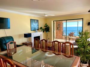 a living room with a glass table and chairs at VISTAMAR CORACEROS VIÑA DEL MAR in Viña del Mar
