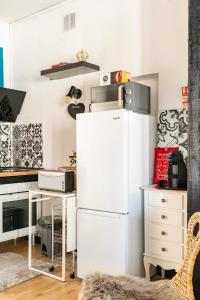 a kitchen with a white refrigerator and a desk at Lisbon Garden Stays, with BBQ, Easy Parking near Tejo, Fast Access to Alfama & Downtown in Lisbon