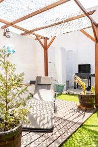 a patio with a chair under a pergola at Cozy House in Lisbon with Terrace, Tejo Peek and Easy Parking in Lisbon