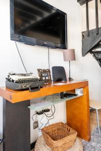 uma secretária com um monitor de computador e um teclado em Cozy Haven Retreat em Lisboa