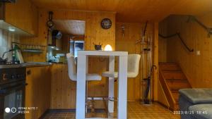una cocina con 2 sillas blancas en una habitación en Le Charlot, en Saas-Grund