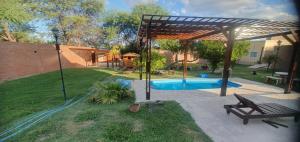 un patio trasero con piscina y pabellón en EL CHALET en Termas de Río Hondo