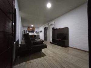 ein Wohnzimmer mit einem Sofa und einem TV in der Unterkunft Vicenzo 2 in Melo