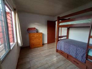 梅洛的住宿－Vicenzo 2，一间卧室配有双层床、梳妆台和窗户。
