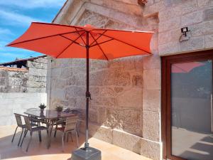 un ombrello rosso seduto sopra un tavolo di Villa Boas House a Castro Daire